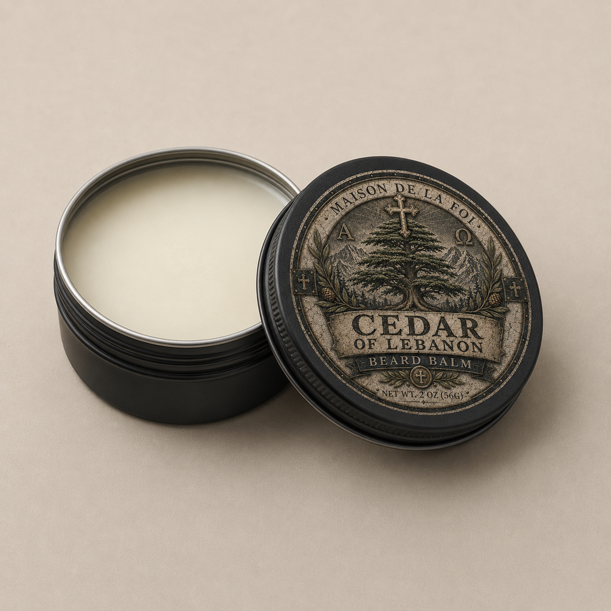 An open round black metal tin of beard balm with pale cream balm visible inside, next to the lid. The lid has an illustrated label reading 'Maison de la Foi' and 'Cedar of Lebanon Beard Balm' on a warm beige background.